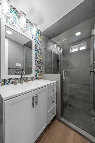 a bathroom with a double vanity sink mirror and shower