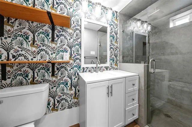 a bathroom with a sink and mirror with toilet
