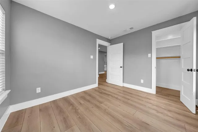 a view of an empty room with wooden floor
