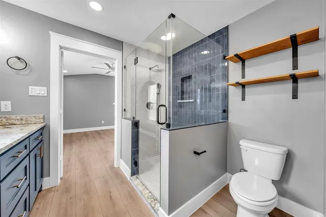 a bathroom with a shower a toilet and a sink