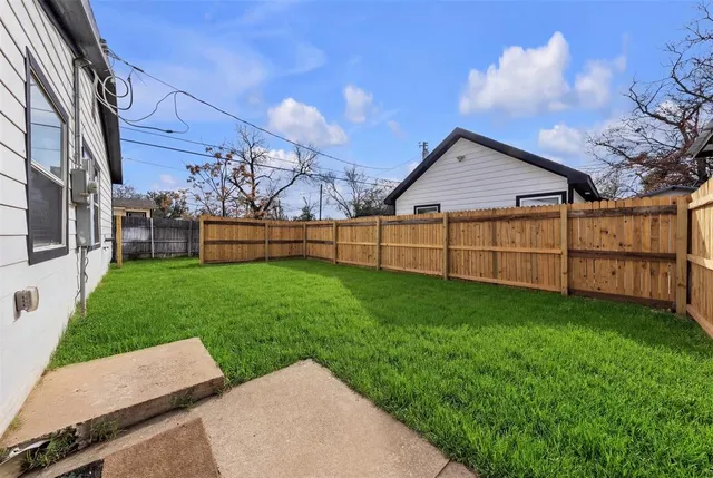 a view of a backyard with wooden fence