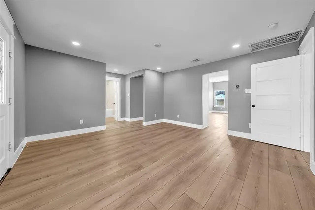 a view of an empty room with wooden floor