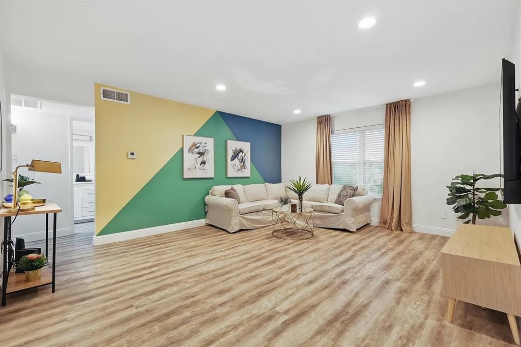 Living area with light wood-style flooring and recessed lighting