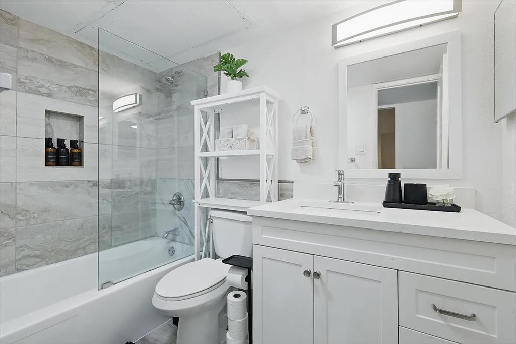 8083 Meadow Road, Unit 265 Dallas, TX 75231 - Photo 19 of 22 Bathroom with bath / shower combo with glass door and vanity