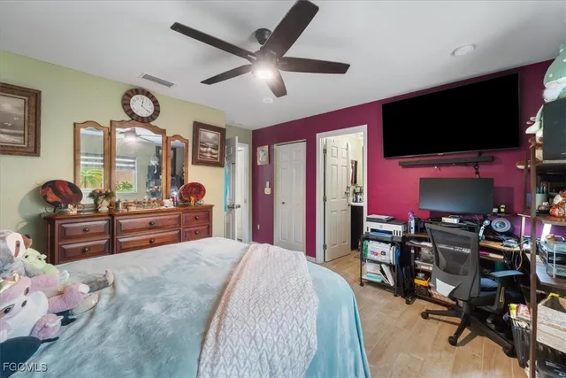 a spacious bedroom with a bed and a flat screen tv