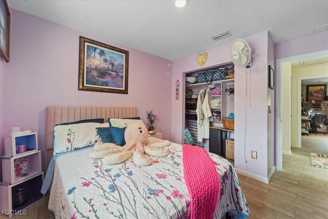 a bedroom with bed and wooden floor