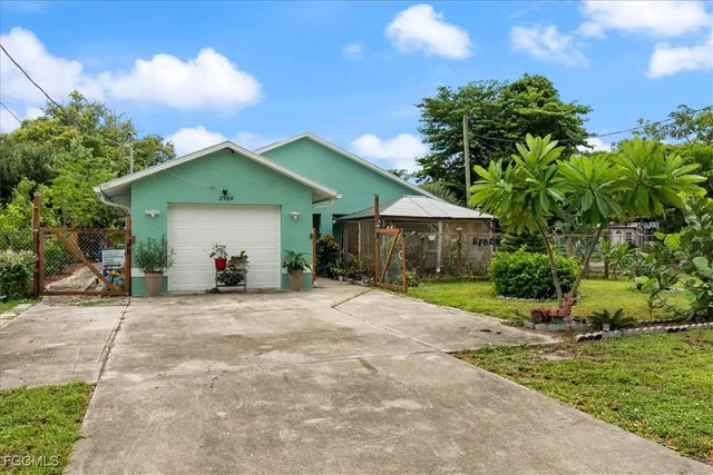 a view of a house with a yard and large tree