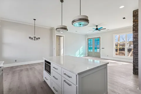 a kitchen with stainless steel appliances granite countertop a sink a stove and a wooden floor