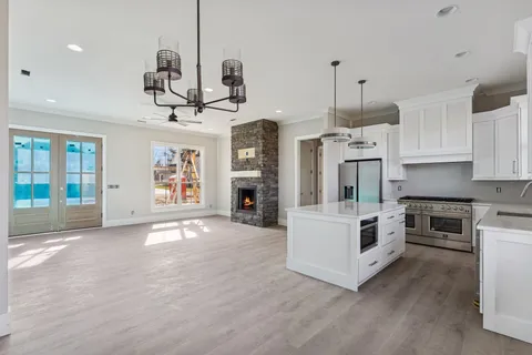 a view of kitchen with sink a microwave and cabinets