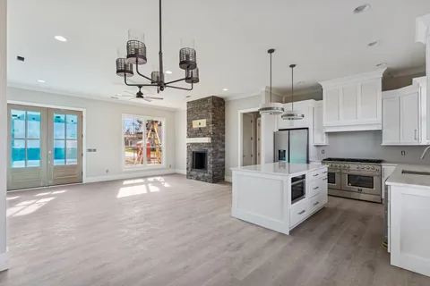 a view of kitchen with sink a microwave and cabinets