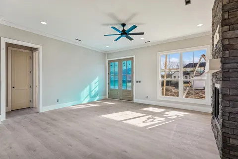 a view of an empty room with a window and a kitchen