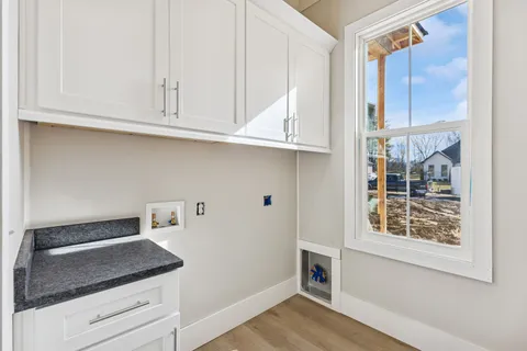 a kitchen with white cabinets and a window