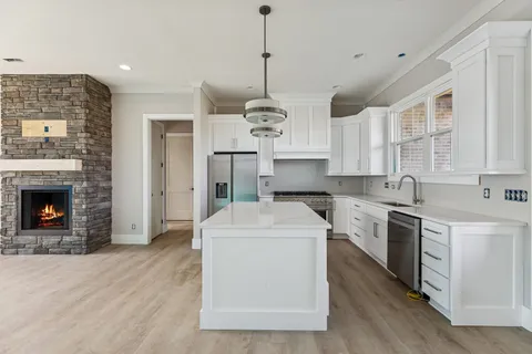 a kitchen with stainless steel appliances granite countertop a sink stove and refrigerator