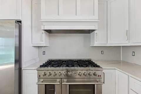a stove top oven sitting inside of a kitchen