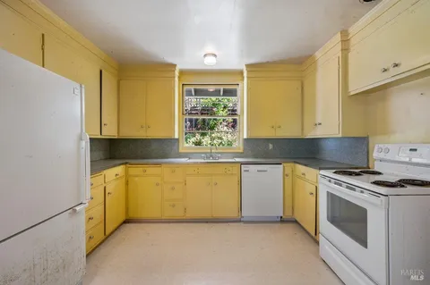 a kitchen with granite countertop white cabinets and white appliances