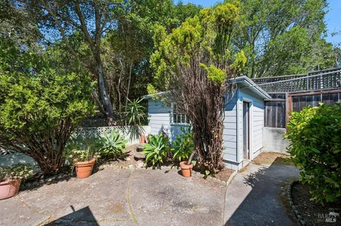 a view of a house with potted plants and large trees