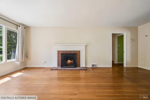 a view of empty room with wooden floor and fireplace