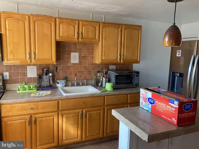 a kitchen with stainless steel appliances granite countertop a sink a stove and a wooden cabinets