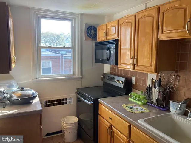 a kitchen with a sink cabinets and a stove top oven