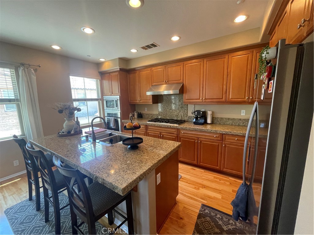 a kitchen with a refrigerator a stove a sink dishwasher with a dining table and chairs