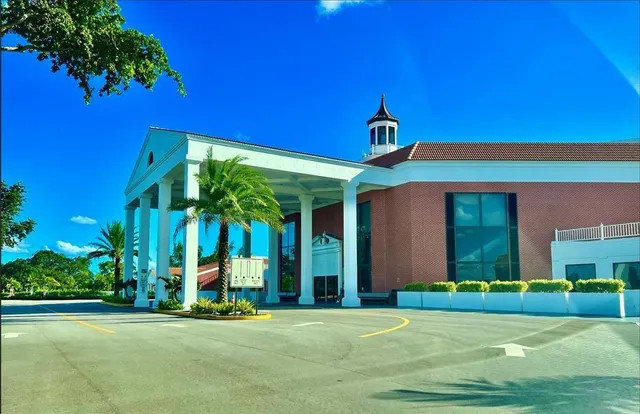 a living room with stainless steel appliances furniture a large window and a bookshelf