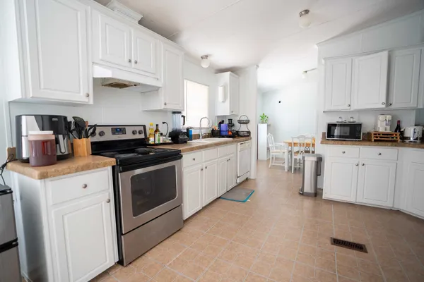 a kitchen with white cabinets and white appliances