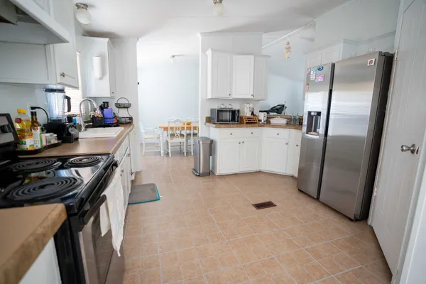 a kitchen with stainless steel appliances granite countertop a refrigerator stove top oven a sink and dishwasher