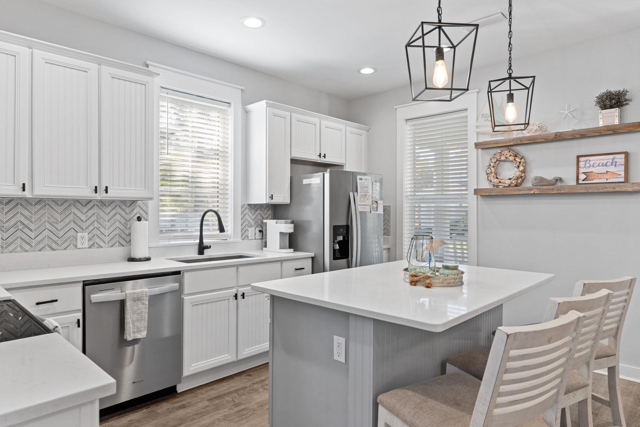 1352 Ravens Run West Miramar Beach, FL 32550 - Photo 15 of 50 a kitchen with a sink stools a counter space and cabinets