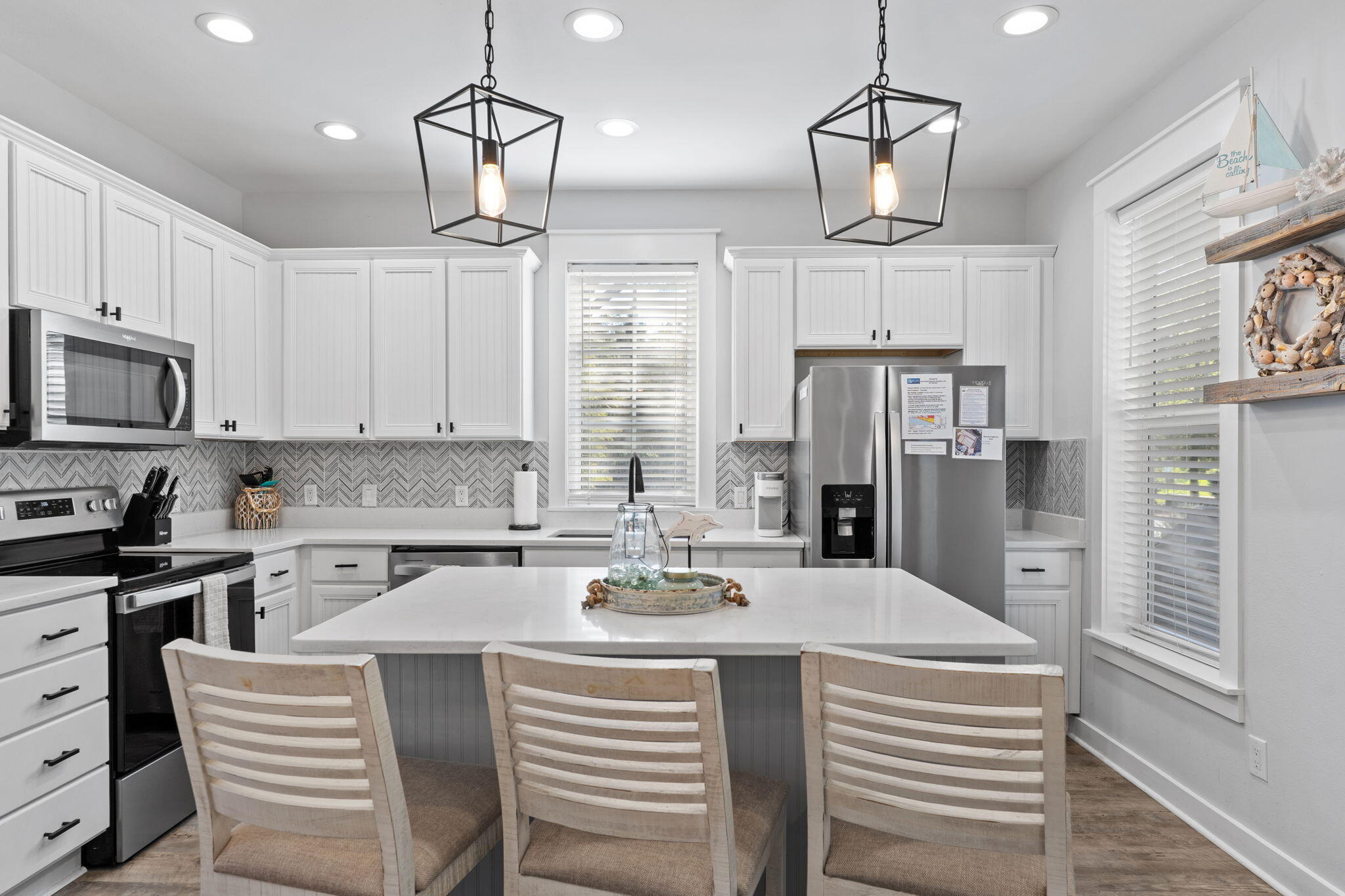 1352 Ravens Run West Miramar Beach, FL 32550 - Photo 18 of 50 a kitchen with stainless steel appliances a dining table chairs refrigerator and microwave