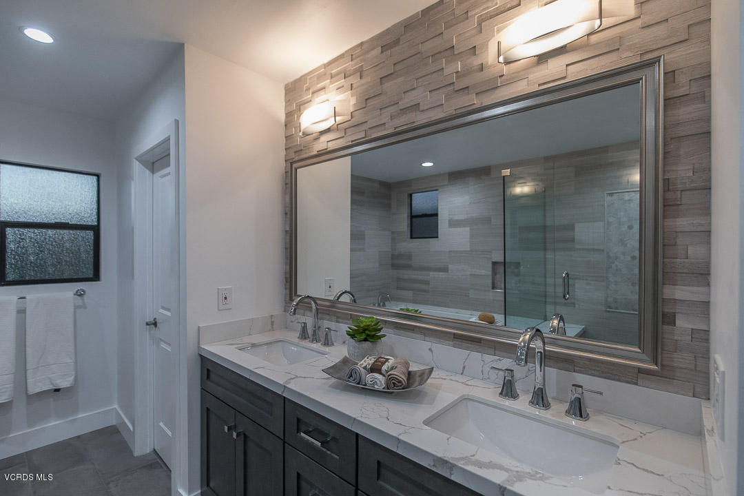 3812 Westfall Drive Encino, CA 91436 - Photo 29 of 52 a bathroom with a granite countertop sink a large mirror and shower
