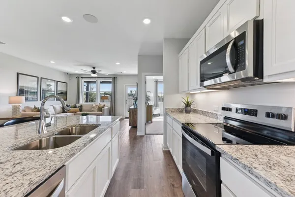 a kitchen with stainless steel appliances granite countertop a sink a stove oven and granite counter tops