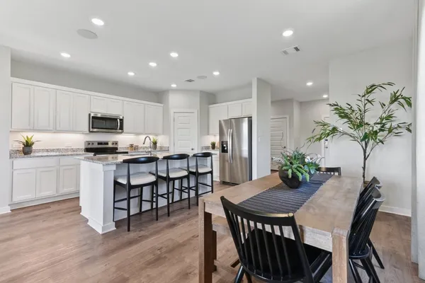 a kitchen with granite countertop white cabinets and stainless steel appliances