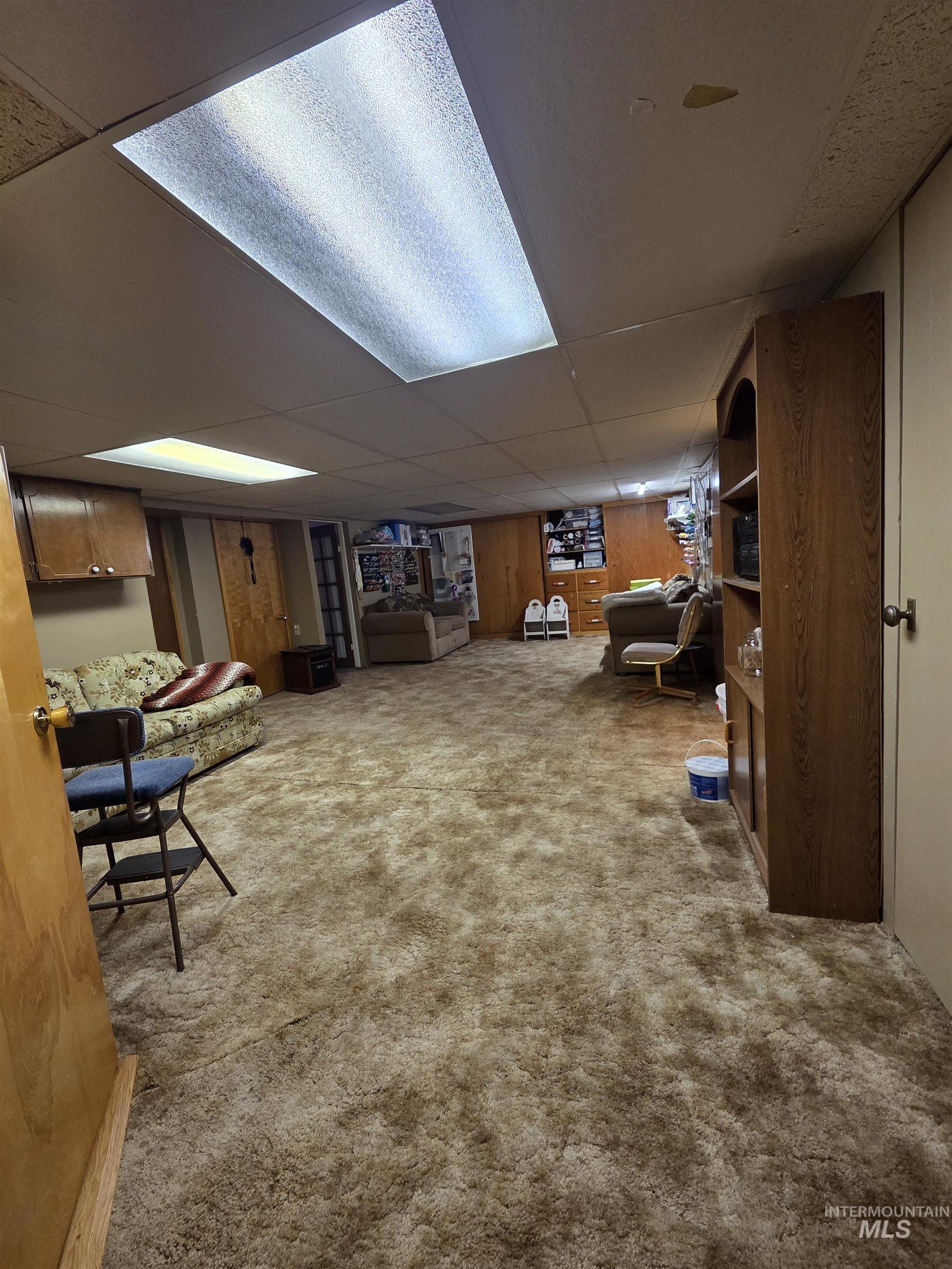 109 South 3rd Street Pomeroy, WA 99347 - Photo 21 of 36 Spacious room featuring neutral-toned carpeting, ample built-in shelving, and wood-finish wall paneling