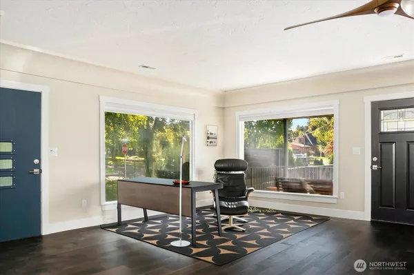 a living room with furniture floor to ceiling window and wooden floor