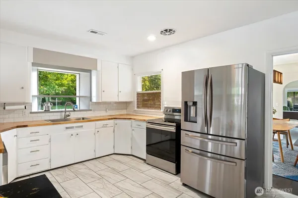 a kitchen with white cabinets and stainless steel appliances