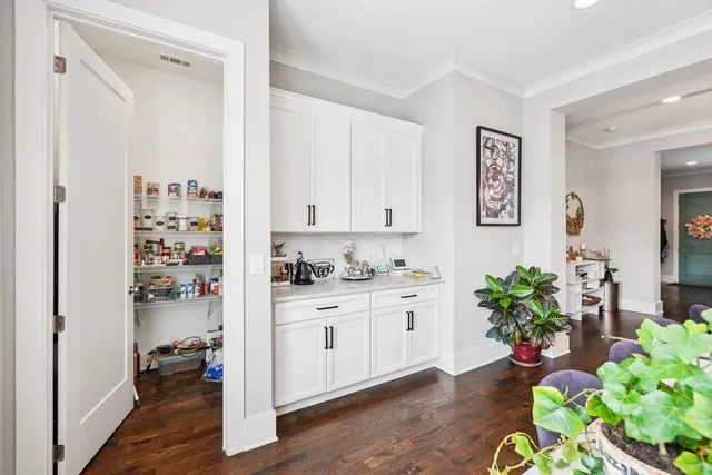a kitchen with white cabinets and wooden floor