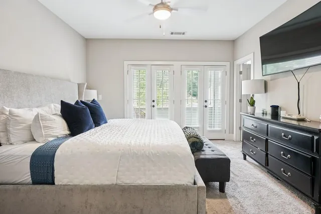 a spacious bedroom with a bed and a flat screen tv