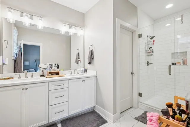 a bathroom with a double vanity sink mirror and shower