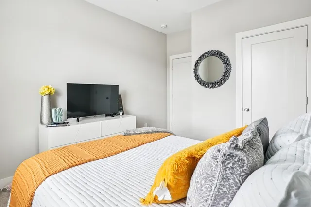 a bedroom with a bed and flat screen tv