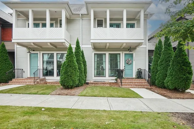 a view of a brick house with a yard and plants
