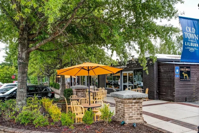 a view of a patio with chairs and a table and chairs under an umbrella