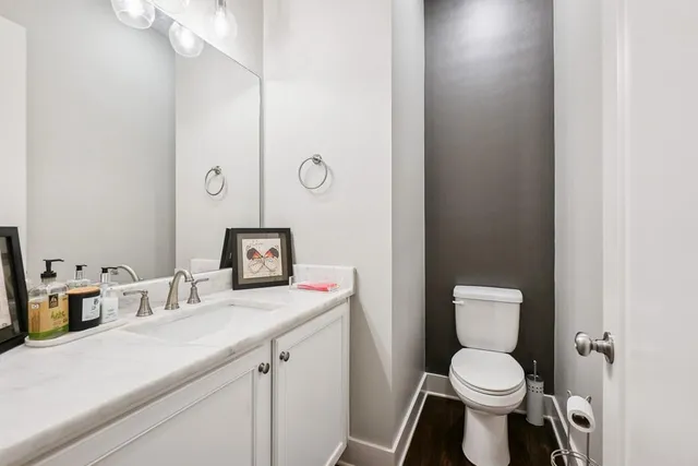 a bathroom with a toilet sink vanity and mirror