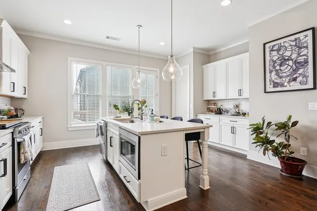 a kitchen with a sink stove and wooden floor