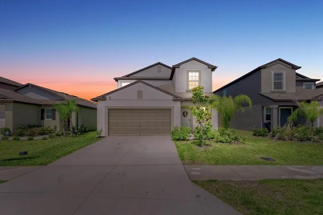 a front view of a house with a yard and garage
