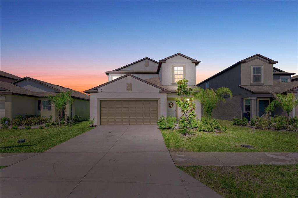 a front view of a house with a yard and garage