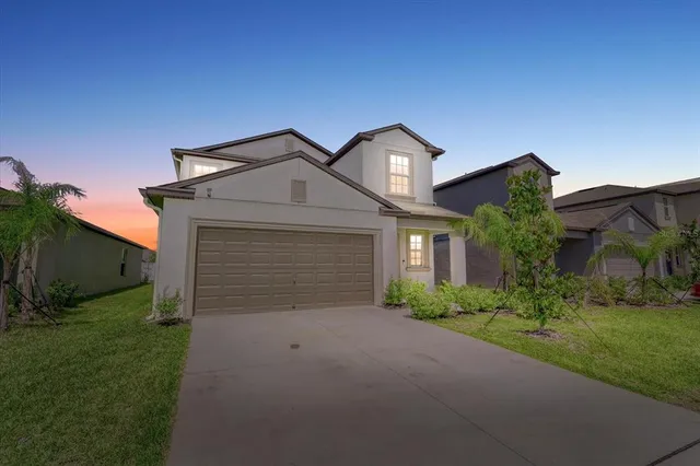 a front view of a house with a yard and garage
