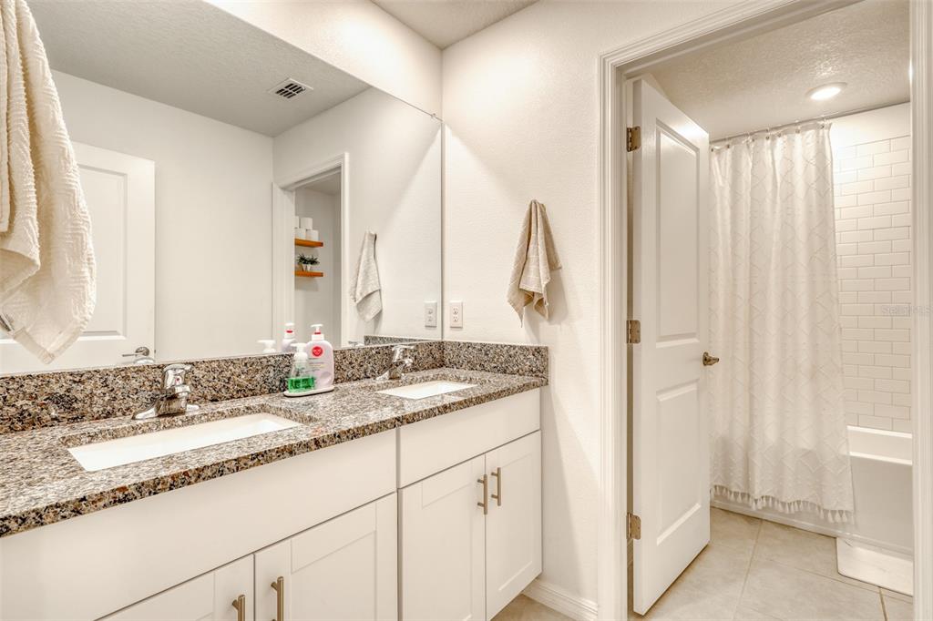 111 Rain Lily Ave Spring Hill Spring Hill, FL 34609 - Photo 17 of 60 a bathroom with a granite countertop sink and a mirror
