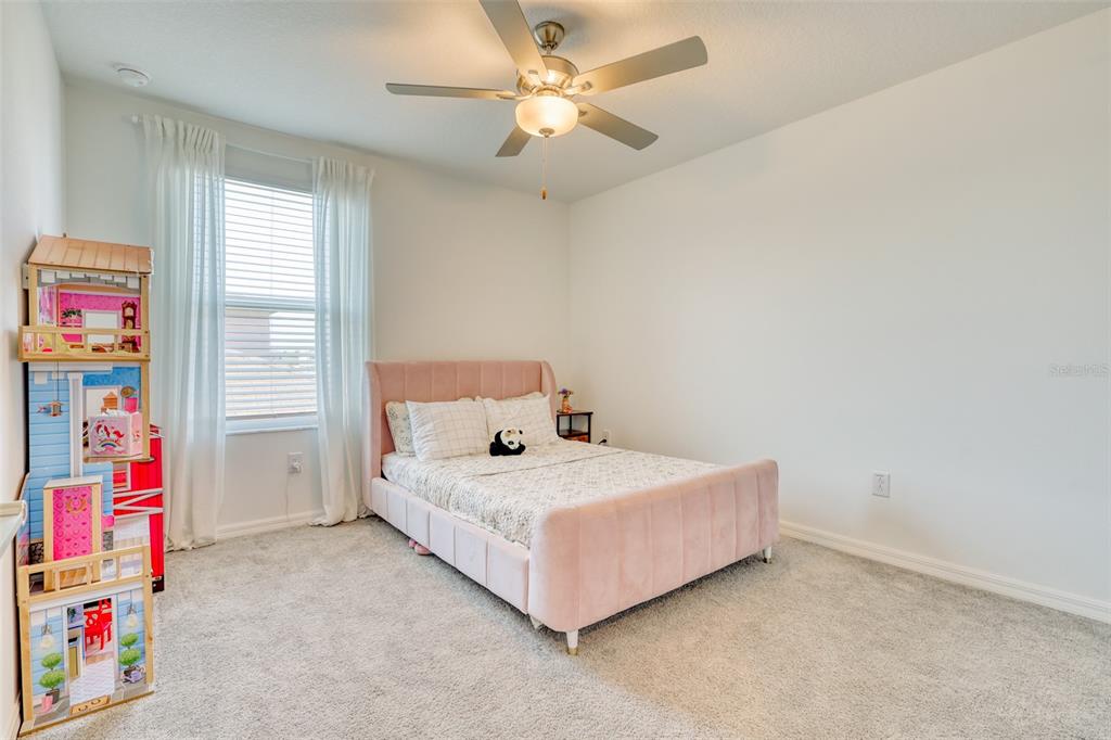 111 Rain Lily Ave Spring Hill Spring Hill, FL 34609 - Photo 18 of 60 a bedroom with a bed and a chandelier