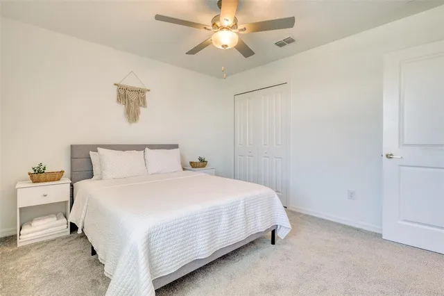 a bedroom with a bed and a ceiling fan