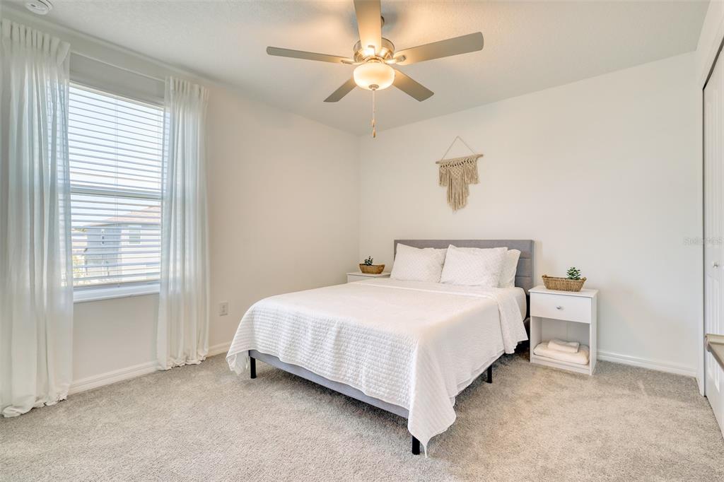 111 Rain Lily Ave Spring Hill Spring Hill, FL 34609 - Photo 20 of 60 a bedroom with a bed and a ceiling fan